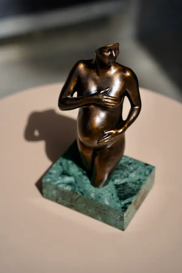 Sculpture de grossesse Arte-Lumina teinte bronze sur un socle en marbre vert