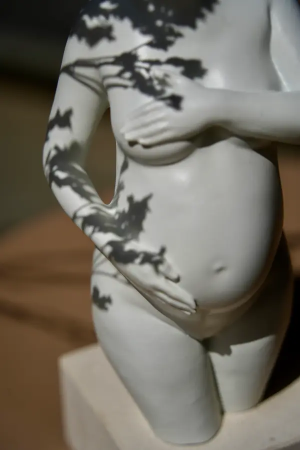 Sculpture de grossesse Arte-Lumina blanche, ombres de feuilles au soleil